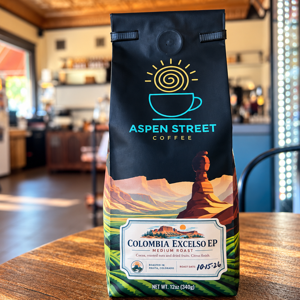 Aspen Street Coffee bag of Colombia Excelso medium roast beans displayed on a wooden café table.